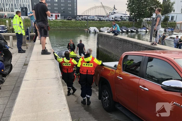Omgeslagen boot wordt opgetakeld in jachthaven