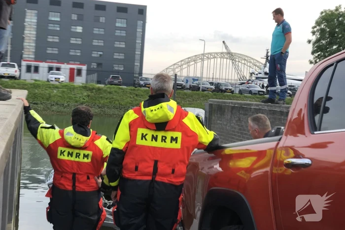 Omgeslagen boot wordt opgetakeld in jachthaven