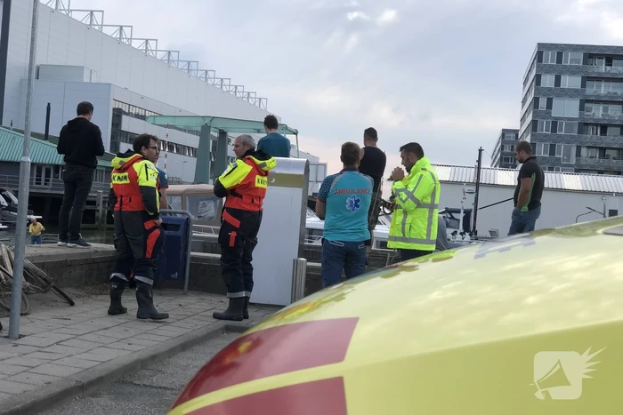 Omgeslagen boot wordt opgetakeld in jachthaven
