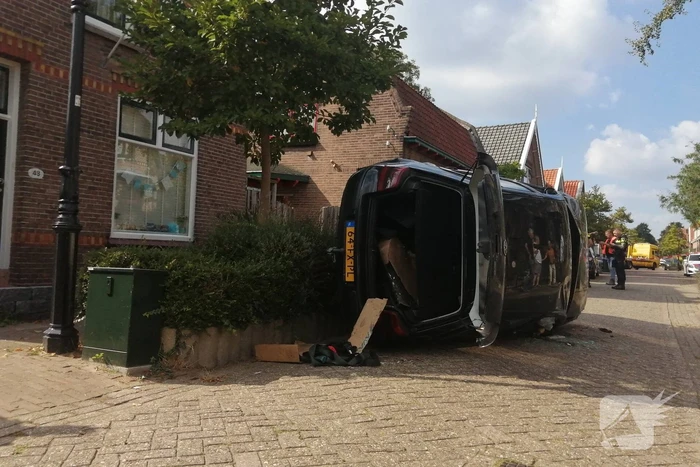 Personenauto belandt op zijn zijkant in woonwijk