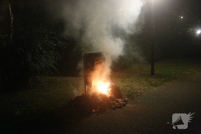 Brandweer blust brand bij prullenbak