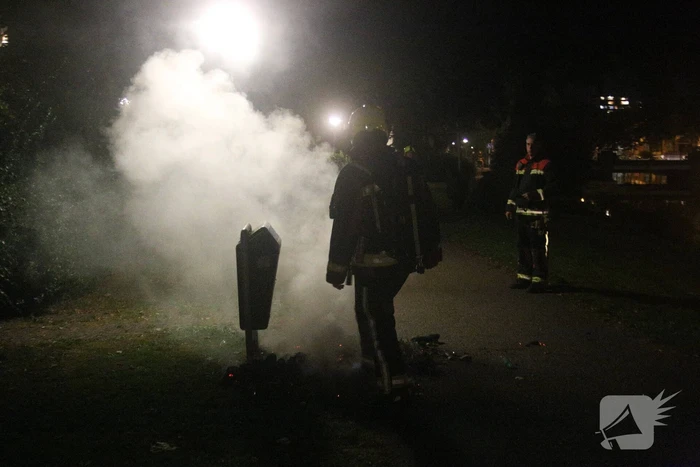 Brandweer blust brand bij prullenbak