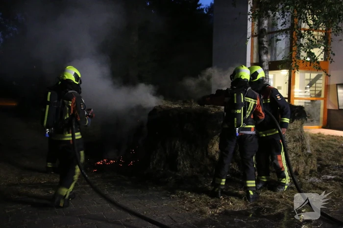 Brandweer blust brand in meerdere hooibalen