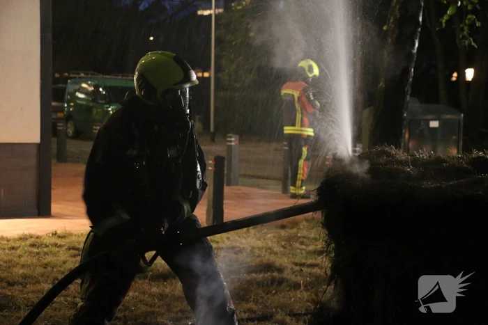 Brandweer blust brand in meerdere hooibalen