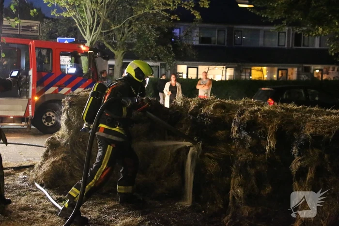 Brandweer blust brand in meerdere hooibalen