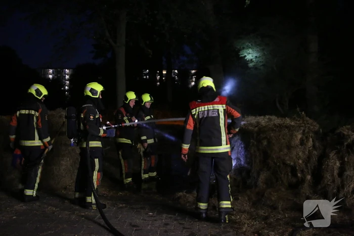 Brandweer blust brand in meerdere hooibalen