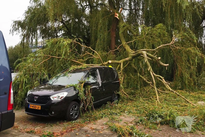 Tak breekt af en belandt op auto