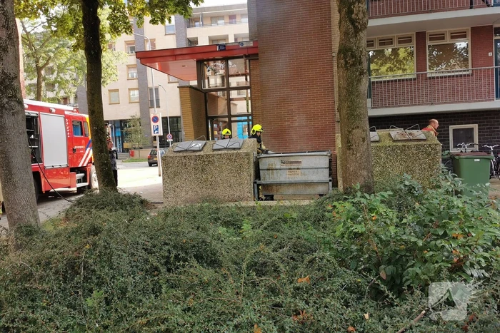 Brandweer blust brand in papiercontainer