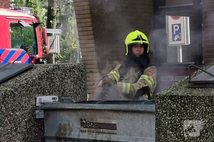 Brandweer blust brand in papiercontainer