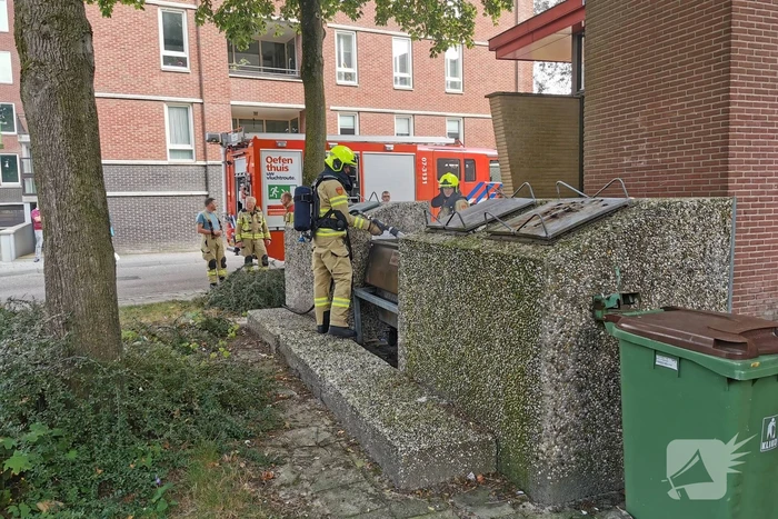 Brandweer blust brand in papiercontainer