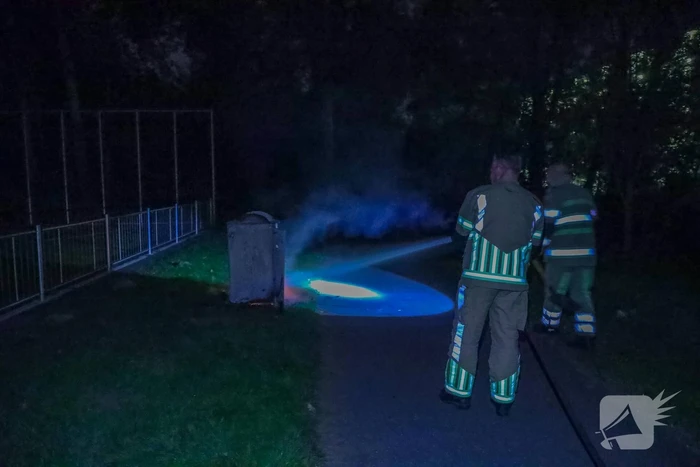 Brandweer blust brand in afvalcontainer