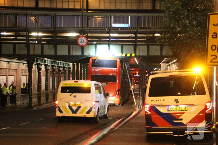 Stadsbus van R-NET rijdt zich klem onder spoorviaduct