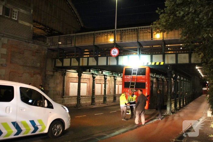 Stadsbus van R-NET rijdt zich klem onder spoorviaduct
