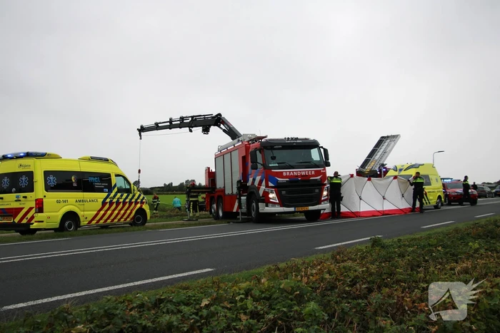 Auto raakt na botsing van de weg en belandt op de kop in weiland