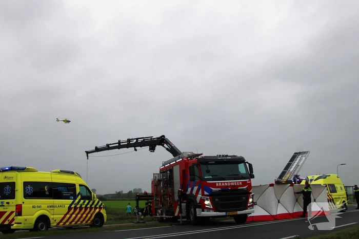 Auto raakt na botsing van de weg en belandt op de kop in weiland