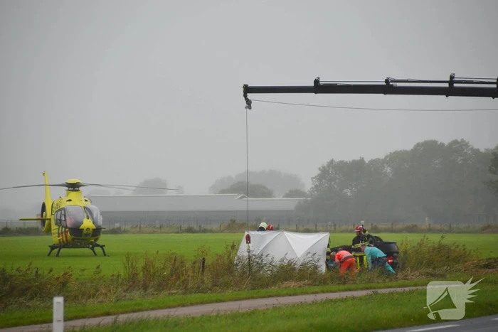 Auto raakt na botsing van de weg en belandt op de kop in weiland