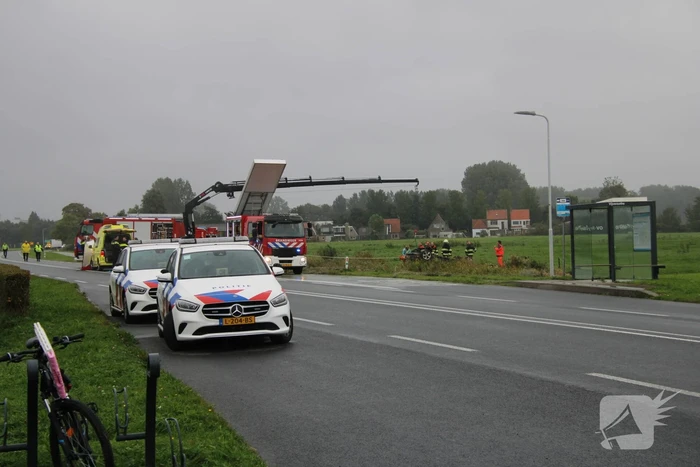 Auto raakt na botsing van de weg en belandt op de kop in weiland