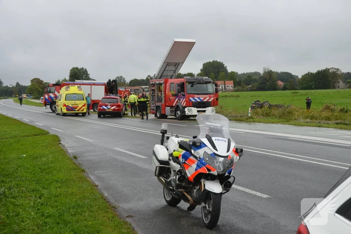 Auto raakt na botsing van de weg en belandt op de kop in weiland