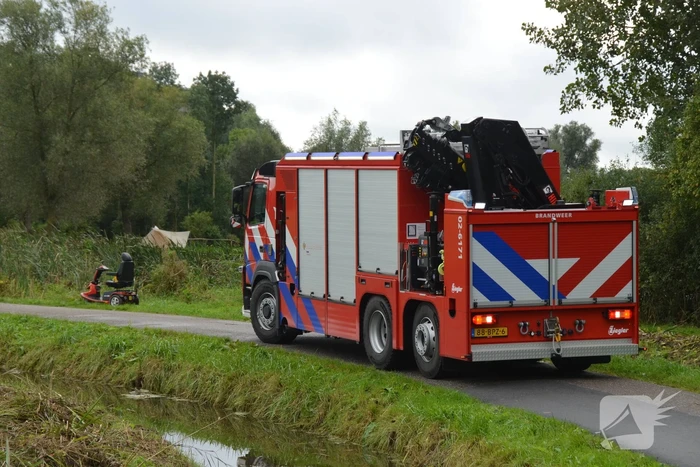 Persoon in scootmobiel raakt te water