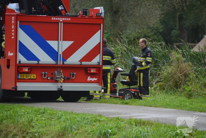 Persoon in scootmobiel raakt te water