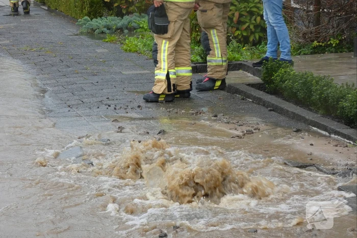 Straat onderwater door gesprongen waterleiding