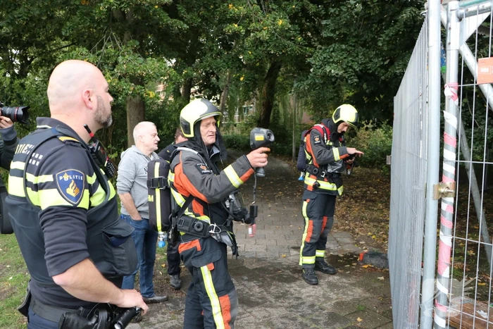 Omstanders blussen brand op bouwplaats