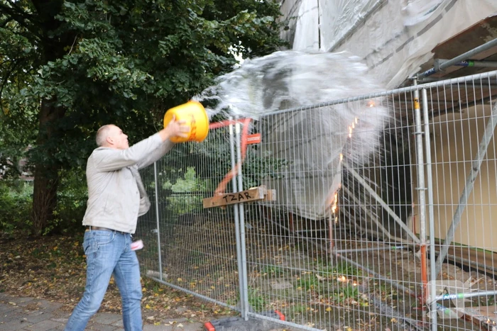 Omstanders blussen brand op bouwplaats