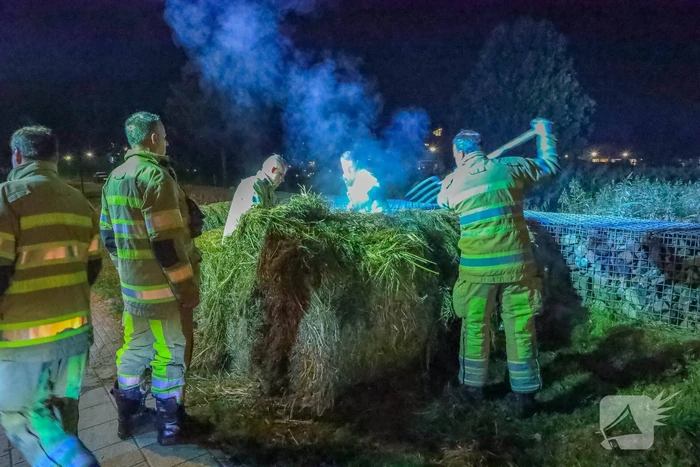 Broeiende hooibalen uit elkaar gehaald