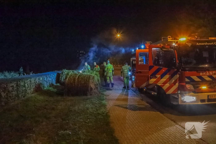 Broeiende hooibalen uit elkaar gehaald