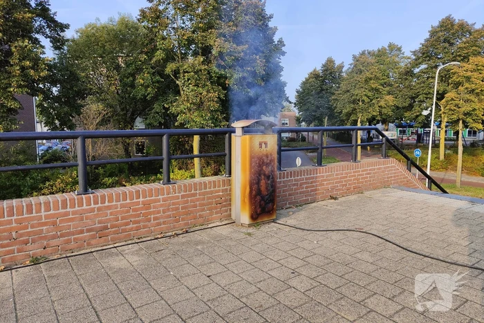Prullenbak in brand op parkeerterrein
