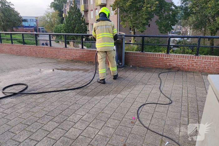 Prullenbak in brand op parkeerterrein
