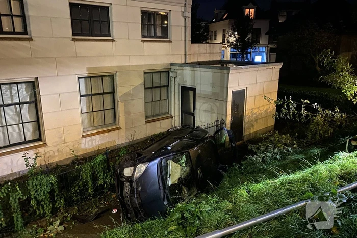 Automobilist raakt van dijk belandt op zijn kant