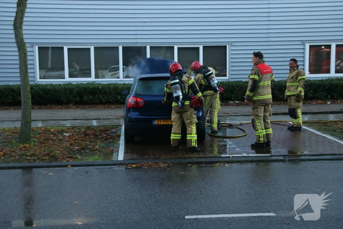 Brandweer blust brand in geparkeerde auto