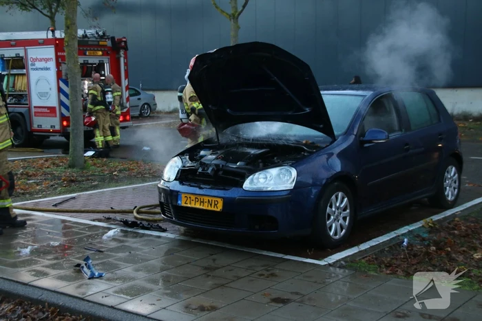 Brandweer blust brand in geparkeerde auto