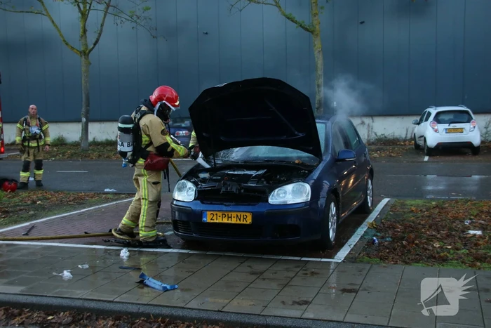 Brandweer blust brand in geparkeerde auto