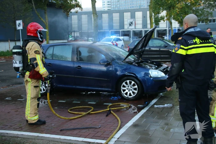 Brandweer blust brand in geparkeerde auto
