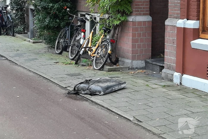 Brandweer haalt kussen uit dakgoot