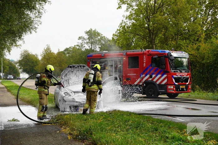 Brandweer blust brand in personenauto