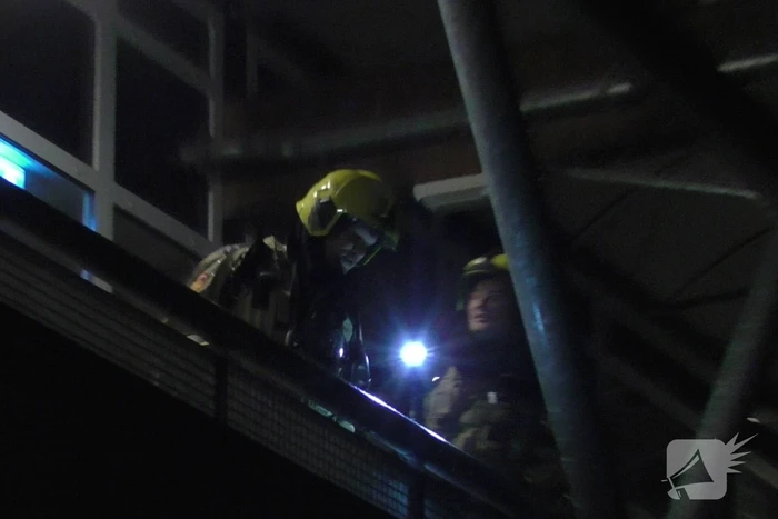 Brandweer blust brandende container tegen school
