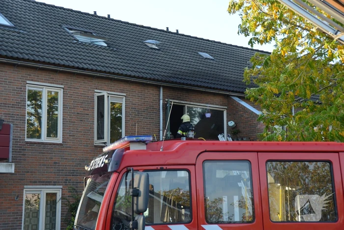 Brandweer blust brand in pan op het vuur