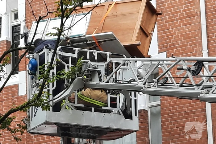 Verhuislift raakt vast in takken van boom