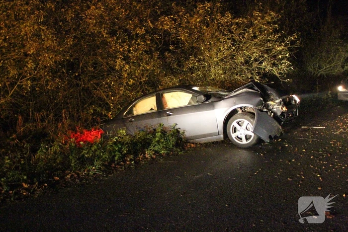 Auto in greppel na botsing met boom
