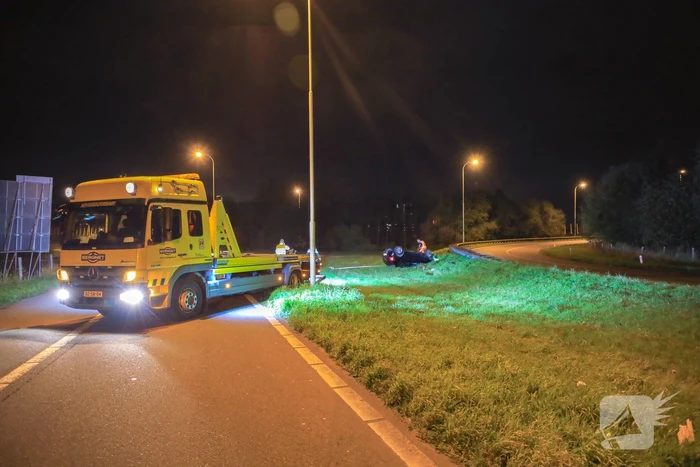 Auto belandt op z'n kop naast snelweg