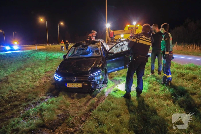 Auto belandt op z'n kop naast snelweg