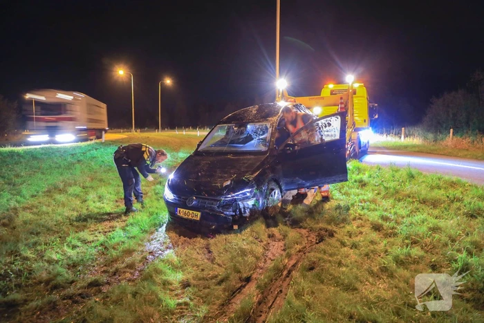 Auto belandt op z'n kop naast snelweg