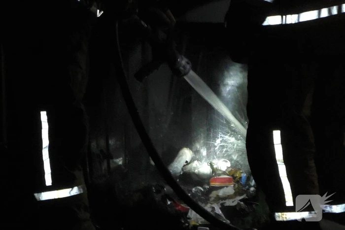 Brandweer blust brandende prullenbak