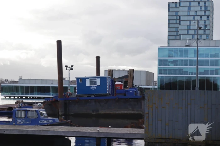 Hijskraan op ponton valt in water