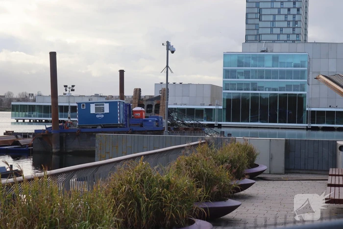 Hijskraan op ponton valt in water