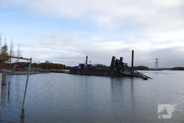 Hijskraan op ponton valt in water