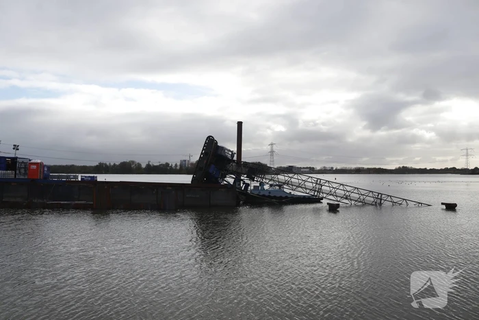 Hijskraan op ponton valt in water